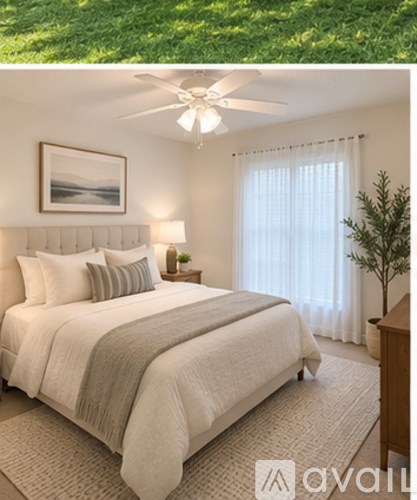 A well-lit bedroom with a large bed and a ceiling fan.