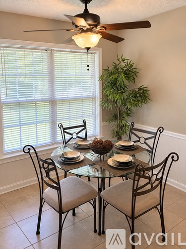 A dining room with a glass table and chairs.