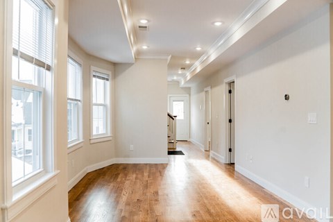A spacious room with wooden floors and white walls.