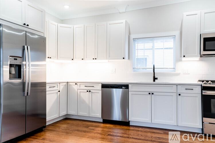 A kitchen with white cabinets and a stainless steel refrigerator.