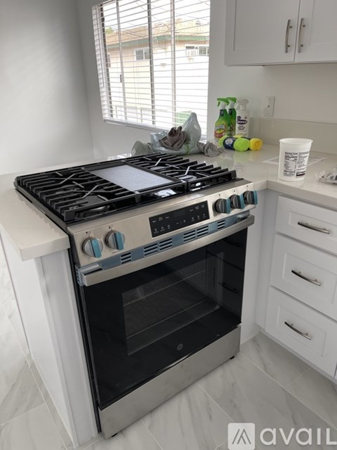 A modern kitchen with a stove top oven and white cabinets.