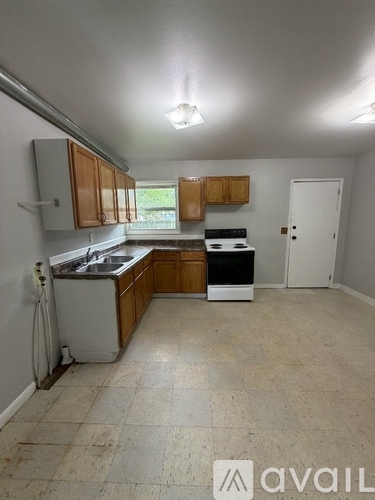 A kitchen with wooden cabinets and a black stove top oven.
