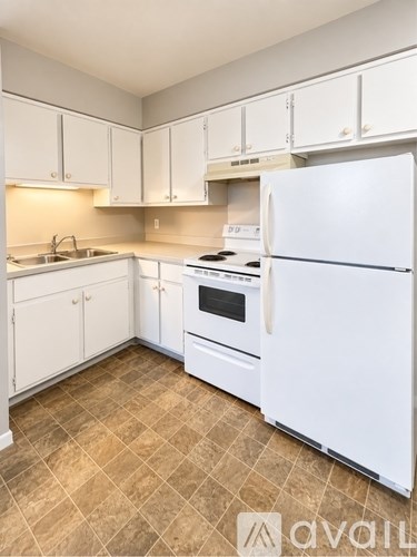A kitchen with white appliances and cabinets.