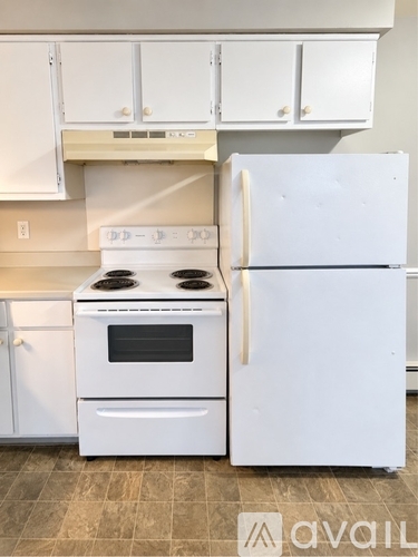 A white stove and refrigerator in a kitchen.