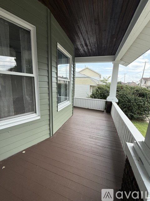 A wooden deck with a railing and a window.