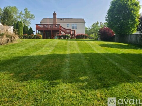 A house with a red roof and a large lawn in front.