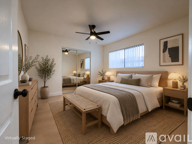A bedroom with a bed, nightstand, and a plant.