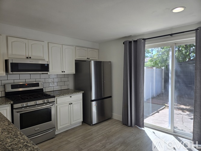 A kitchen with white cabinets and a black stove top oven.