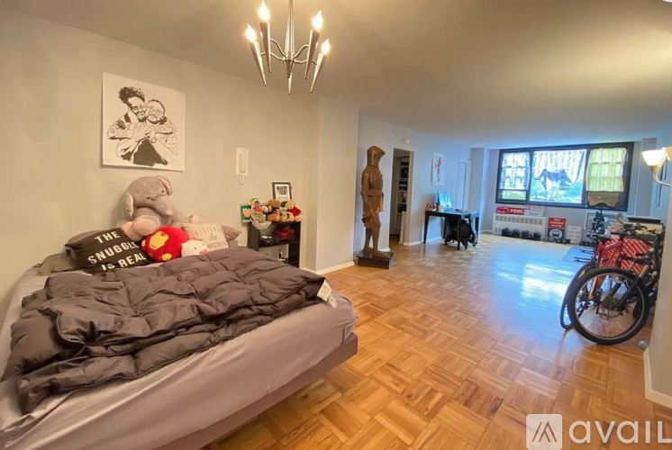 A bedroom with a bed, a bicycle, and a chandelier.