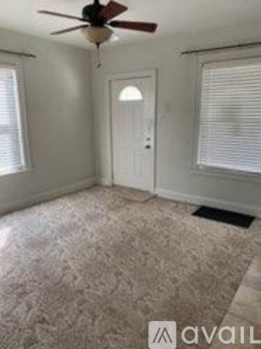 A room with a ceiling fan and a door.