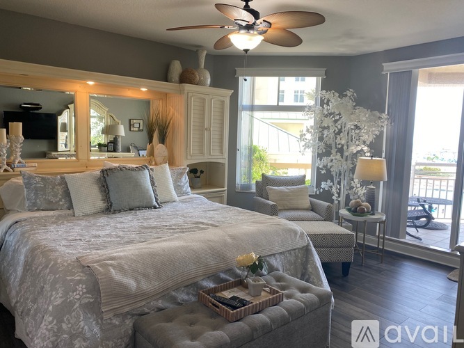 A bedroom with a large bed and a ceiling fan.