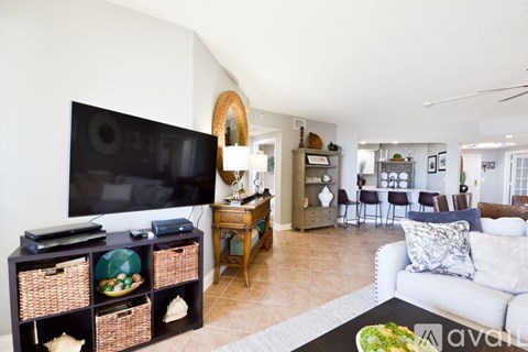 A living room with a white couch and a television.