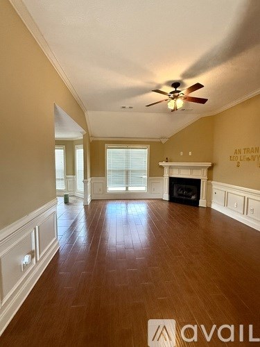 A spacious room with a fireplace and a ceiling fan.