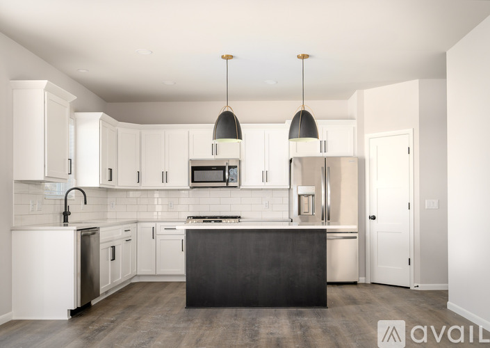 A modern kitchen with white cabinets and a black island.