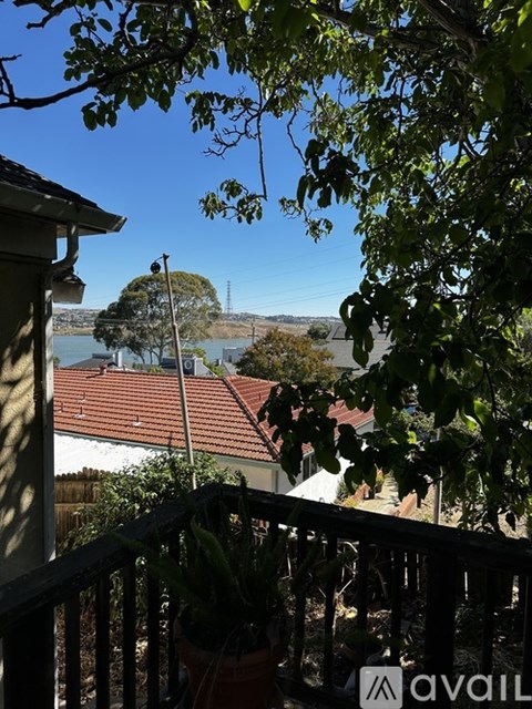 A balcony with a view of a lake and trees.