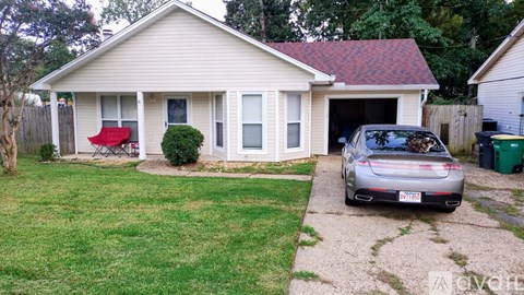 A silver car is parked in front of a house.
