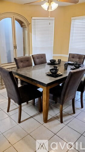 A dining table with chairs and a bowl on it.