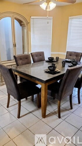 A dining table with chairs and a bowl on it.