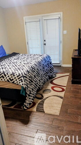 A bedroom with a bed, a dresser, and a television.