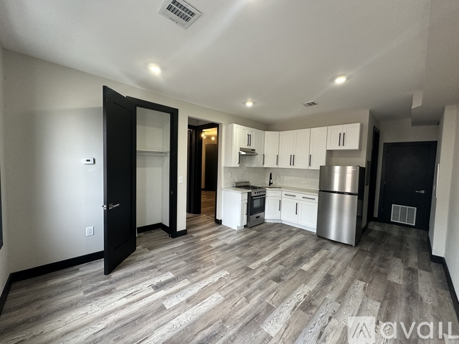A kitchen with a refrigerator, stove, and cabinets.