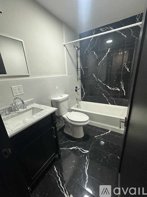 A bathroom with a marble floor and a white toilet.
