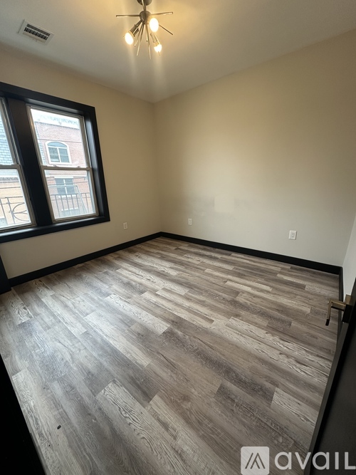 A room with wooden flooring and a window.