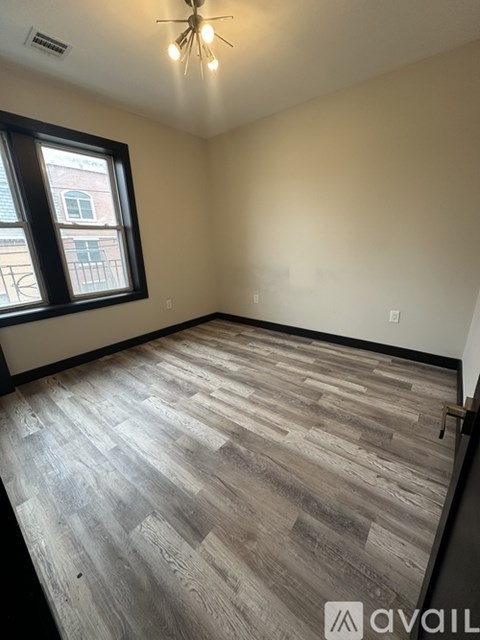 A room with wooden flooring and a window.