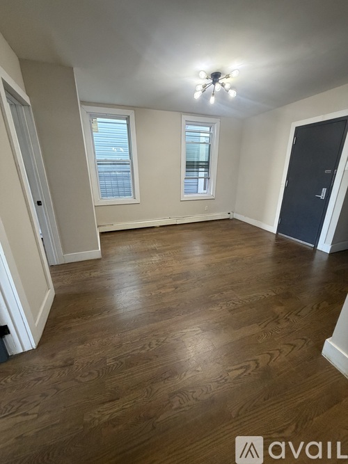 A room with wooden flooring and a ceiling fan.