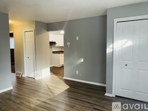 A room with a white door and a wooden floor.