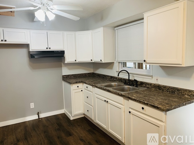 A kitchen with white cabinets and a granite countertop.