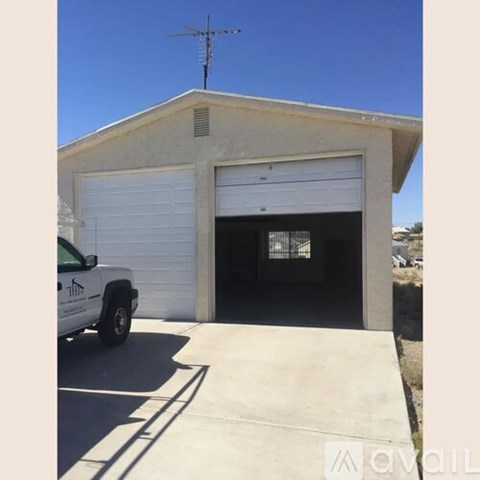 A white garage door is closed and a truck is parked in front of it.