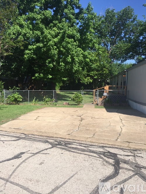 A concrete area with trees in the background.