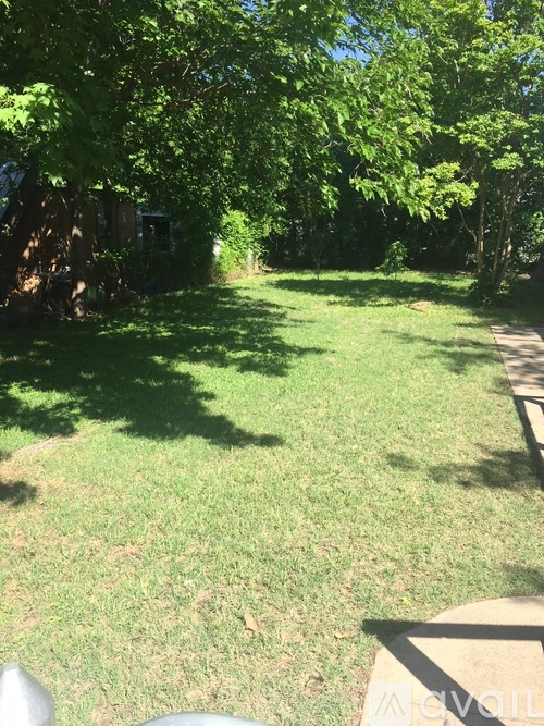 A green lawn with trees and a pathway.