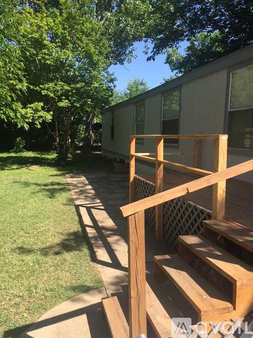 A wooden deck with a lattice fence and a green lawn.