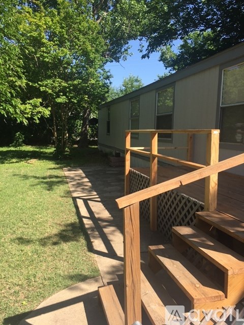 A wooden deck with a lattice fence and a green lawn.