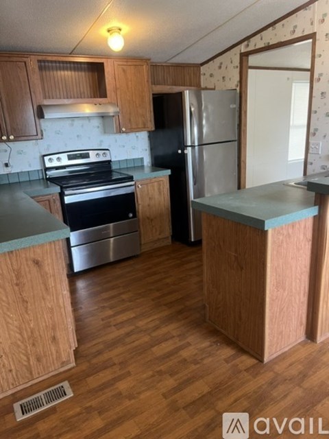 A kitchen with wooden cabinets and a black refrigerator.