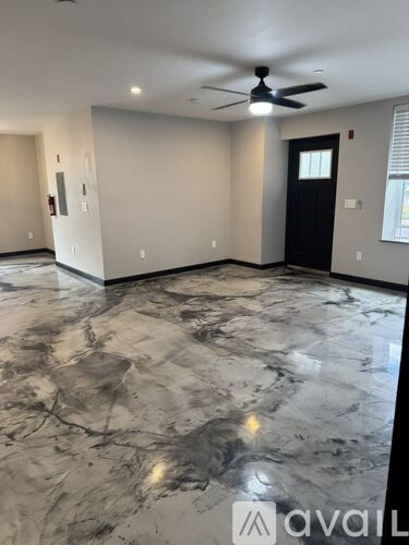 A spacious room with marble flooring and a ceiling fan.