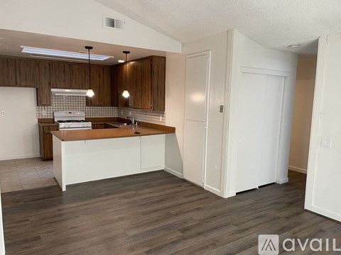 A kitchen with white cabinets and a wooden backsplash.