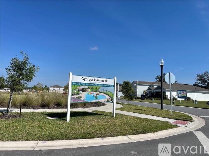 A sign for Cypress Hammock is displayed in front of a building.