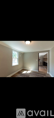 A room with a window and a door leading to another room.