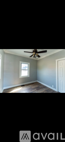 A room with a ceiling fan and a window.
