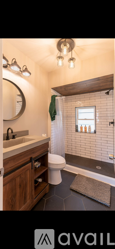 A bathroom with a wooden vanity and a shower with a glass door.