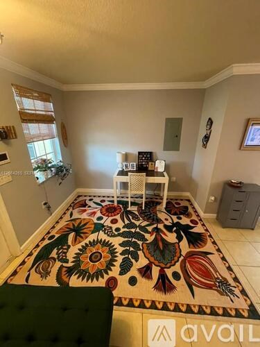A room with a rug on the floor and a green chair.