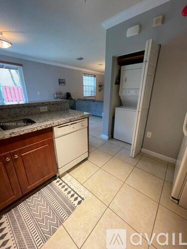 A kitchen with a granite countertop and a refrigerator.