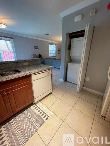 A kitchen with a granite countertop and a refrigerator.