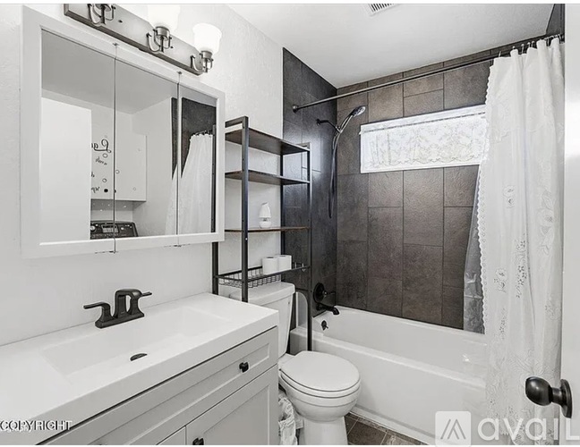 A bathroom with a white toilet, sink, and bathtub.