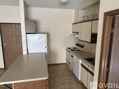 A kitchen with white appliances and a table.