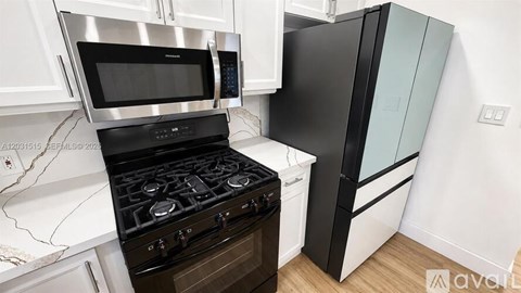 A black and white kitchen with a stove and microwave.