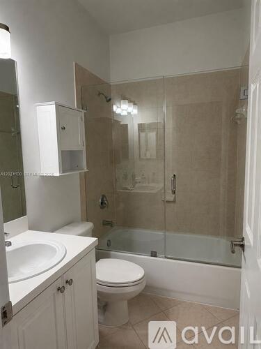 A bathroom with a toilet, sink, and shower.