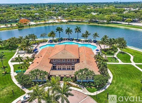 A large house with a pool in the middle of a grassy area.